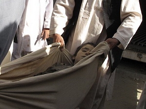 Người dân Afghanistan mang xác của một đứa trẻ, bị chết trong cuộc không kích của NATO, tới một bệnh viên ở Helmand.